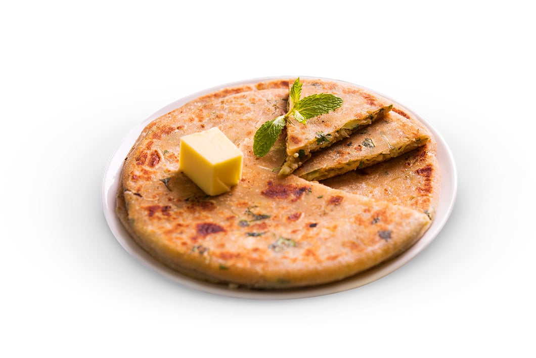 A very delicious looking chicken kheema paratha on a plate with butter and mint leaf upon it.